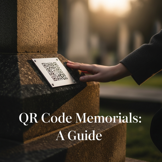 A hand rests near a QR code memorial plaque on a stone monument in a sunlit memorial garden.